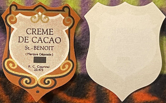 Ornate orange and cream vintage liqueur label for Creme de Cacao St. Benoit by R.C. Courtrai, shown front and back against pu