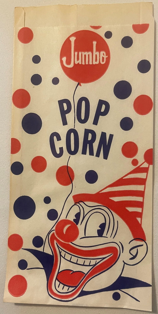 Vintage popcorn bag with red and navy clown face, "Jumbo Pop Corn" text, and scattered circles, displayed flat against beige
