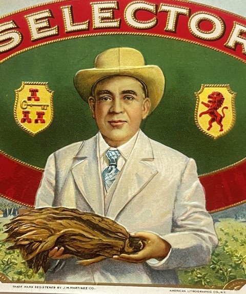 Vintage cigar box label featuring a man in cream suit and cowboy hat holding tobacco leaves against green and red background