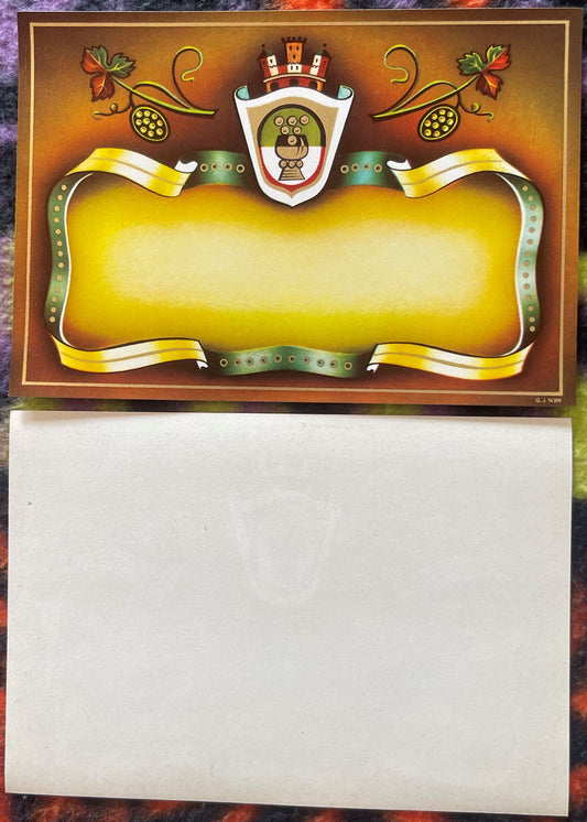 Blank vintage wine label with ornate crest, yellow banner ribbons, grape vines, and decorative shield on brown background, sh