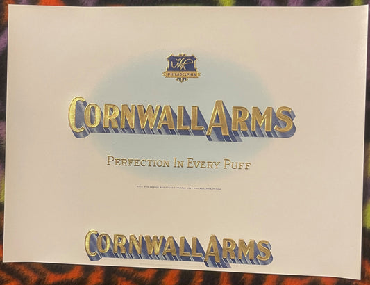 Cream-colored antique cigar label with embossed gold and blue "Cornwall Arms" text, tagline "Perfection In Every Puff," and P