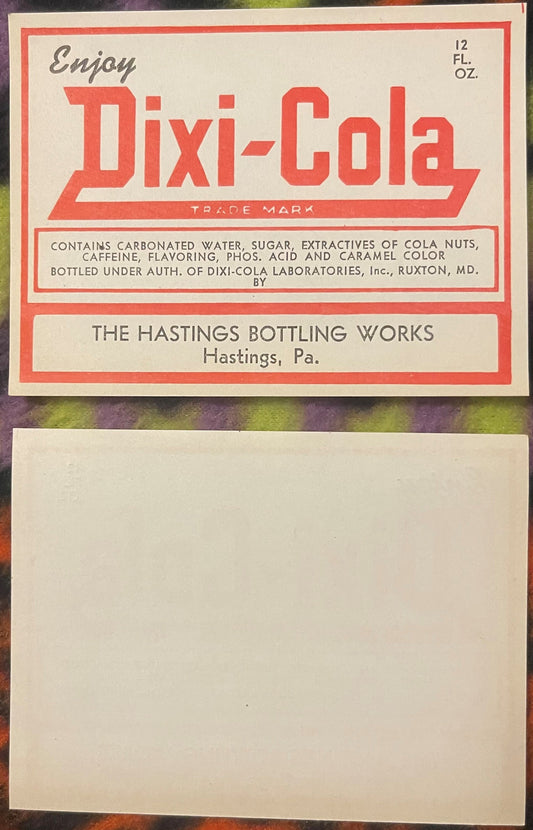 Vintage red and cream Dixi-Cola bottle label from Hastings, Pennsylvania, 12 fl oz, showing front and back sides on colored b
