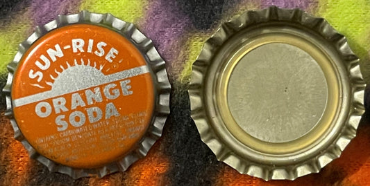 Front and back of vintage Sun-Rise Orange Soda bottle cap with ridged metal edges and white lettering on orange, displayed on