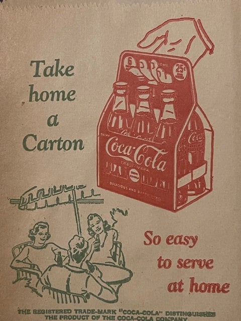 Vintage Coca-Cola paper sleeve advertisement on tan cardboard showing red bottle carton, illustrated family, and text "Take h