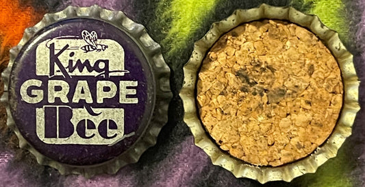 Two views of a vintage King Bee Grape Soda bottle cap showing purple and cream label with bee logo and cork-lined interior de