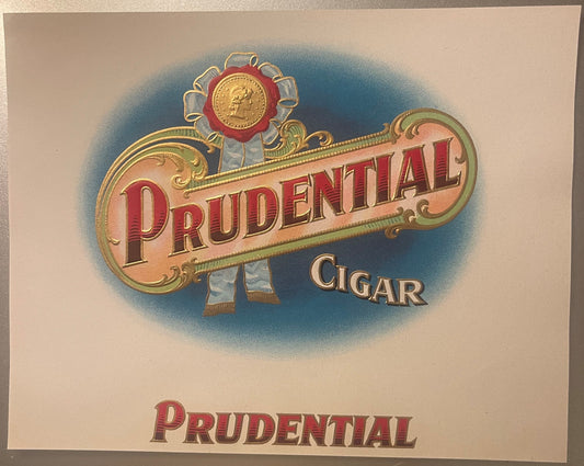 Antique embossed cigar label with "Prudential" in red letters, gold detailing, decorative medal at top, blue background, circ