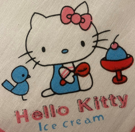 Vintage Hello Kitty cotton napkin with pink bow, blue dress, red shoes, and "Hello Kitty ice cream" text on beige fabric