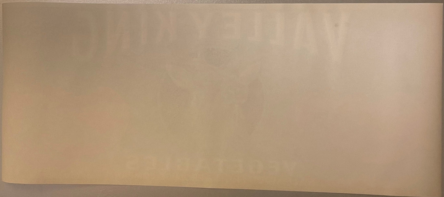Cream-colored vintage vegetable crate label with faded printing, photographed flat against neutral background