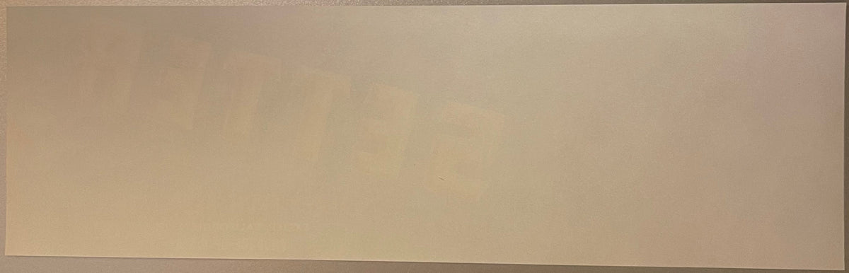 Blank tan-colored vintage crate label with subtle wood grain texture, photographed flat against neutral background