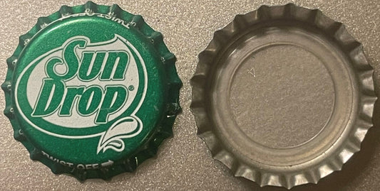 Front and back of a green Sun Drop bottle cap with cream-colored script logo and twist-off crown ridges visible against gray