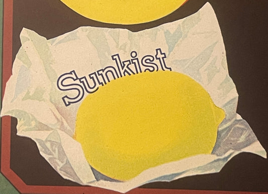 Vintage lemon crate label featuring a bright yellow lemon on cream-colored paper with "Sunkist" text, dark brown background v