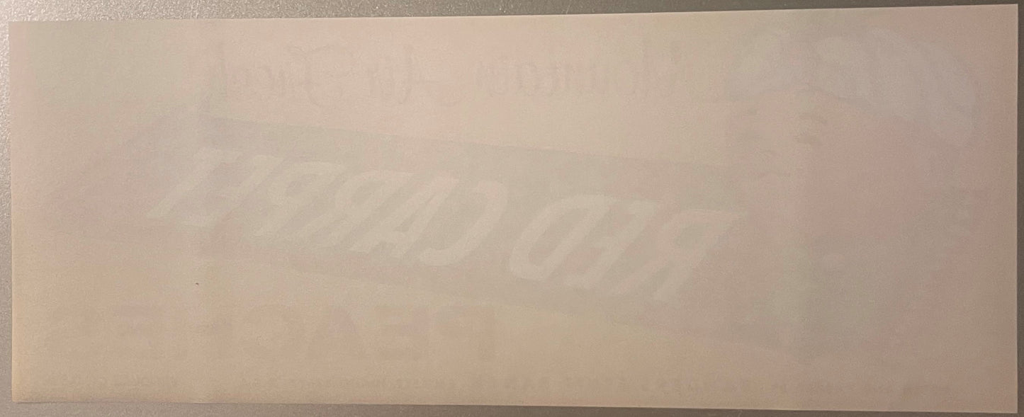 Blank peach crate label with faint watermark text visible against beige background, photographed flat