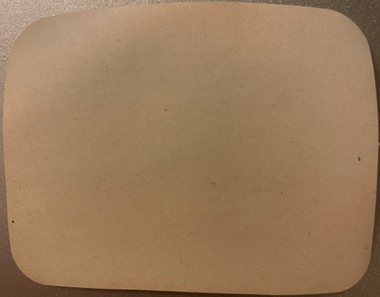 Blank cream-colored rectangular label with rounded corners on textured surface, showing no visible printed text or imagery
