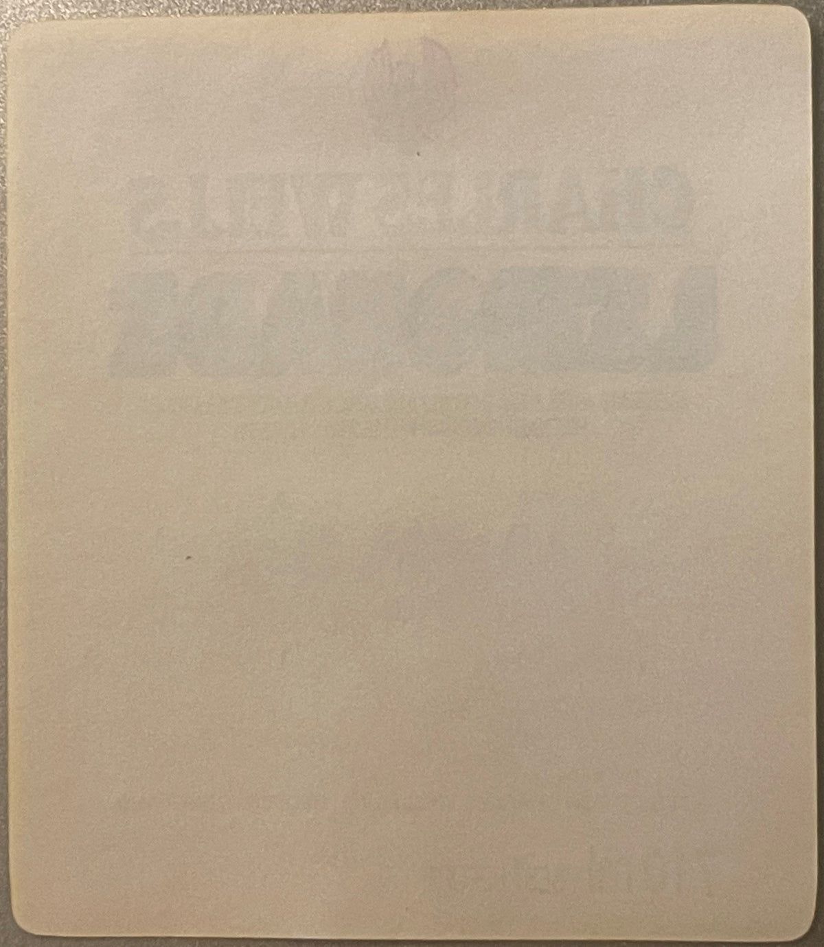 Blank cream-colored page or label backing with rounded corners, shown flat against textured surface