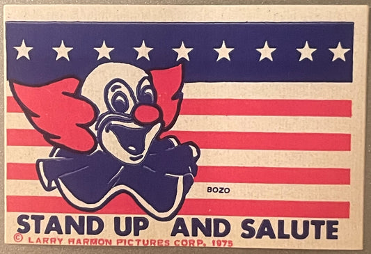 Vintage 1975 Bozo the Clown sticker on American flag background with stars and stripes, text reads "Stand Up and Salute