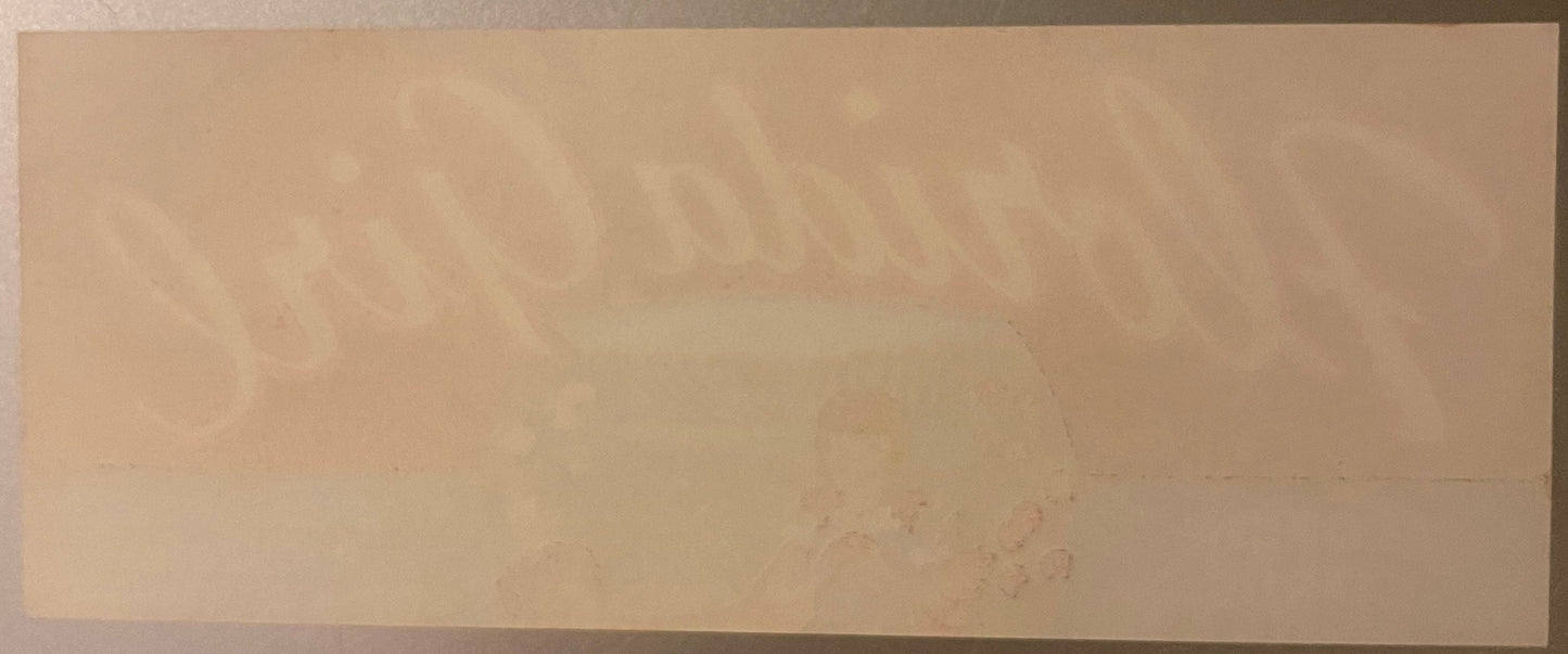 Cream-colored vintage citrus crate label with faint printed text and imagery, showing wear and age marks on paper surface