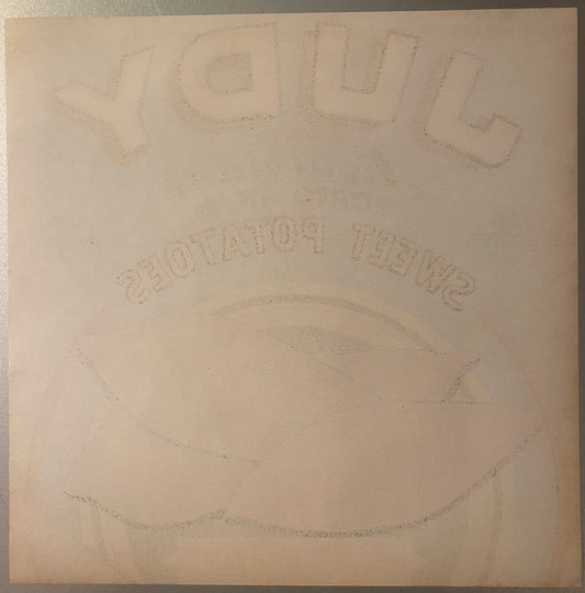 Embossed vintage crate label with "Judy" at top and "Porto Rican" text visible, cream-colored paper with faint circular desig