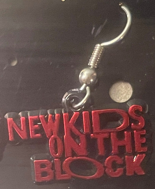 Silver fish hook earring with red "NEW KIDS ON THE BLOCK" text pendant displayed against dark background with coin for scale.