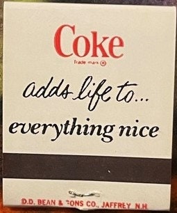 Vintage Coca-Cola matchbook with red "Coke" logo and black cursive text reading "adds life to... everything nice" on cream-co