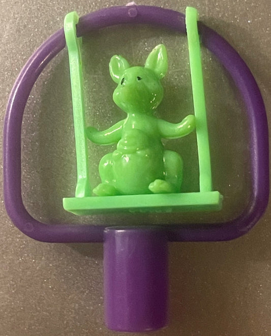 A green kangaroo pencil topper on a lime-green swing inside a purple frame, with a purple pencil socket
