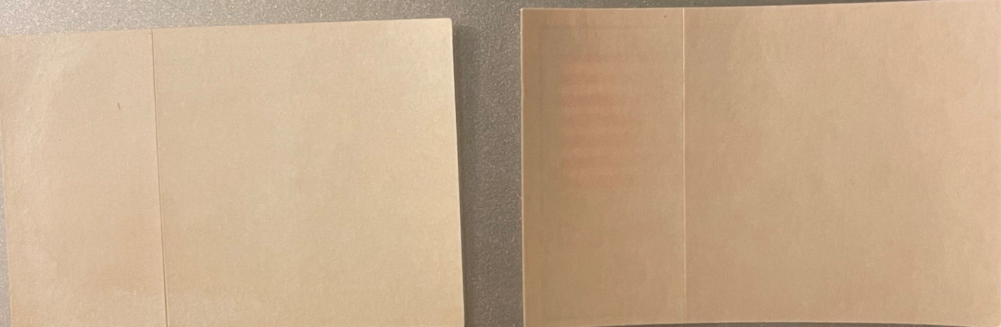 Two opened blank pages of a vintage sticker sheet book with cream-colored pages and visible fold creases, photographed from a