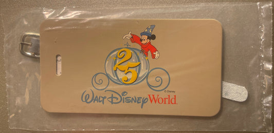 Beige luggage label featuring Sorcerer Mickey and "25" in ornate circle design, Walt Disney World logo below, still in plasti