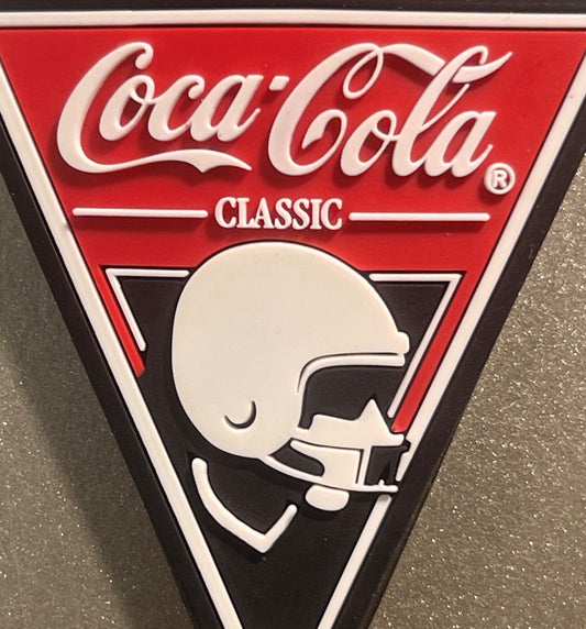 Coca-Cola Classic vintage sign with red background, white script logo, and profile illustration of a face drinking from a bot