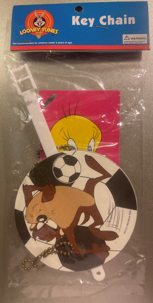 Looney Tunes keychain in clear plastic packaging showing Tweety and Tasmanian Devil characters on white and red rubber tag wi