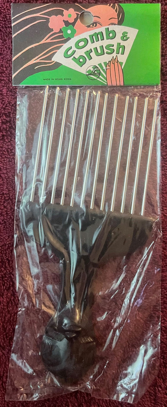 Vintage "Comb & Crush" hair pick with black handle and metal tines, still sealed in original cellophane packaging with illust