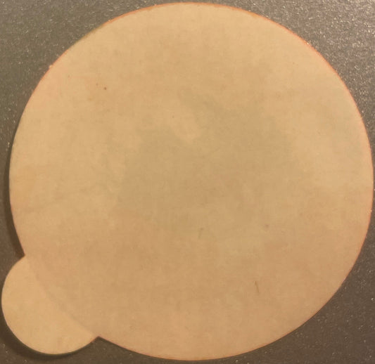 Peach-colored vintage sticker with rounded top and heart-shaped cutout at bottom, shown flat against gray surface