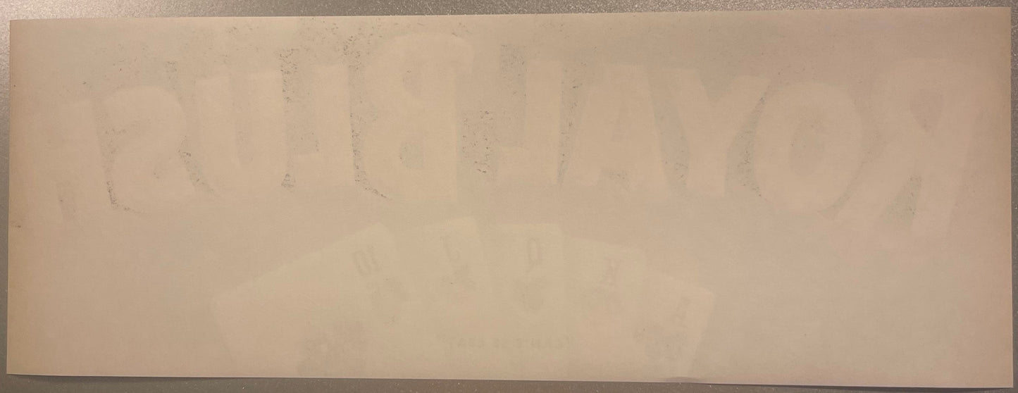 Faded vintage fruit crate label with barely visible text on cream-colored paper, photographed flat against neutral background
