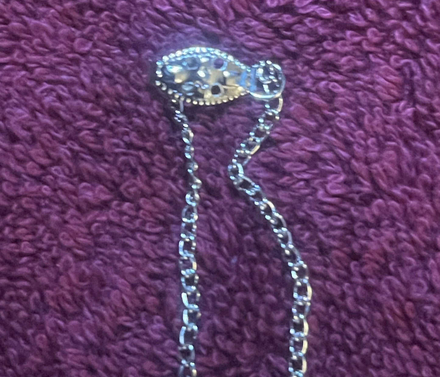 Silver-toned miniature Coca-Cola can pendant on beaded chain necklace, displayed on purple textured fabric