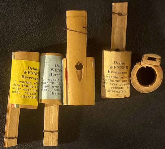 Five wooden Wenner Beverages warblers with yellow and grey labels showing instructions, displayed against dark background.