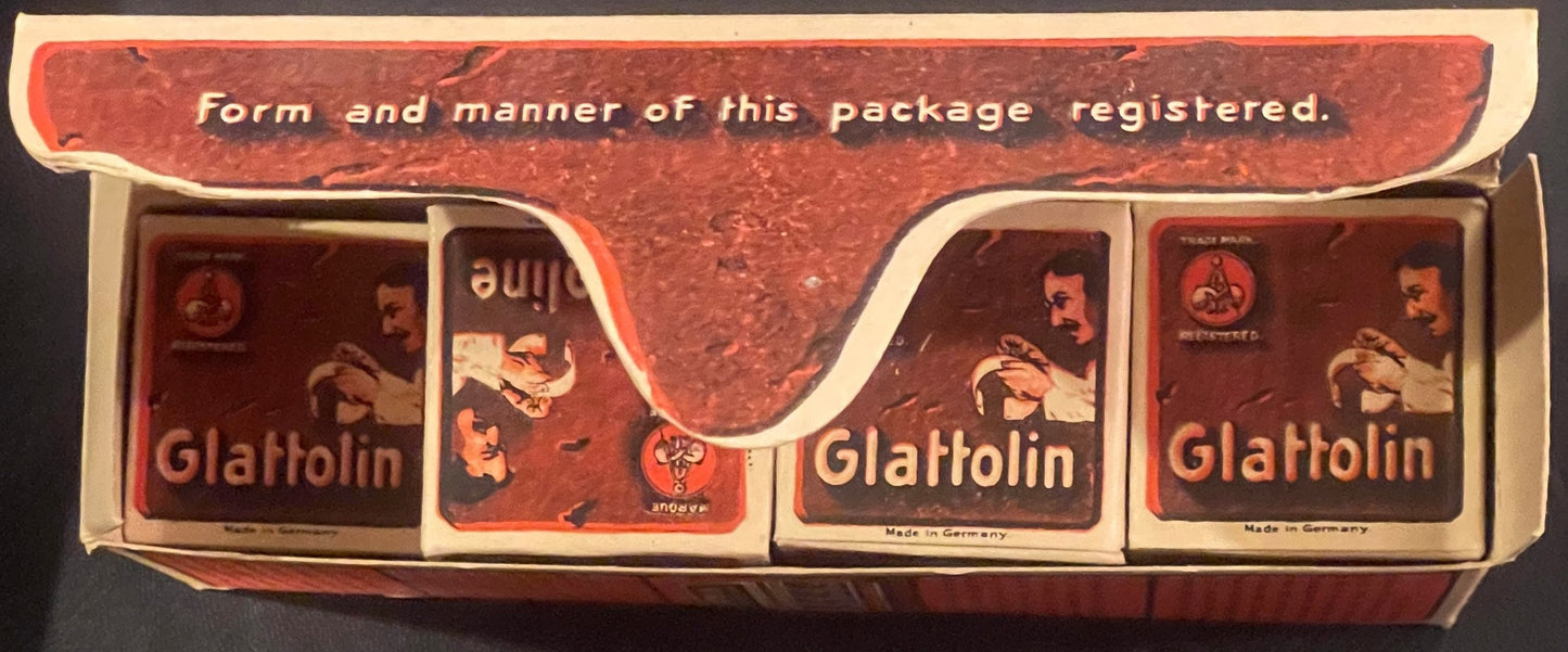 Overhead view of unopened vintage Glattolin wax remedy box with four dark red product boxes visible inside cream-colored pack