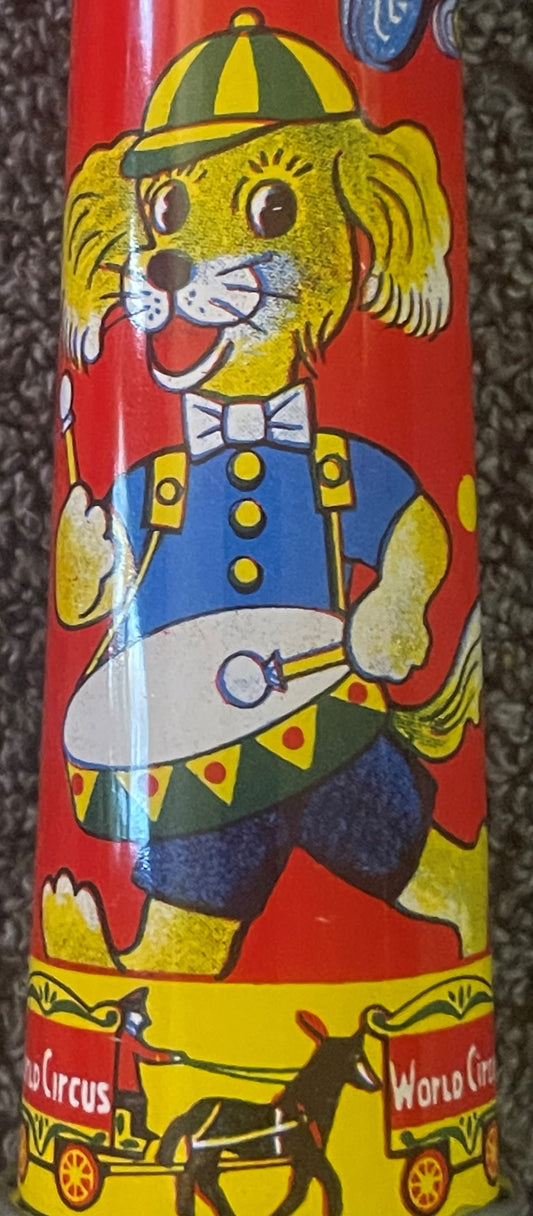 Vintage tin horn noisemaker with yellow dog character wearing striped cap, blue jacket, and bow tie against red background, c