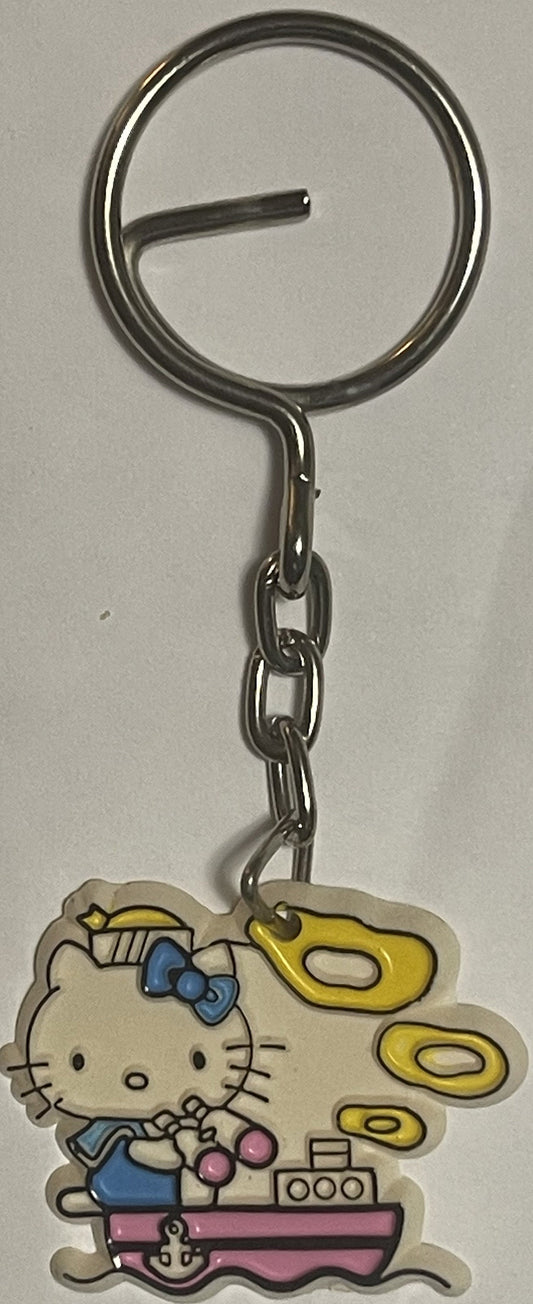 Vintage Hello Kitty sailor boat keychain with blue bow and yellow propellers, metal ring and chain against white background