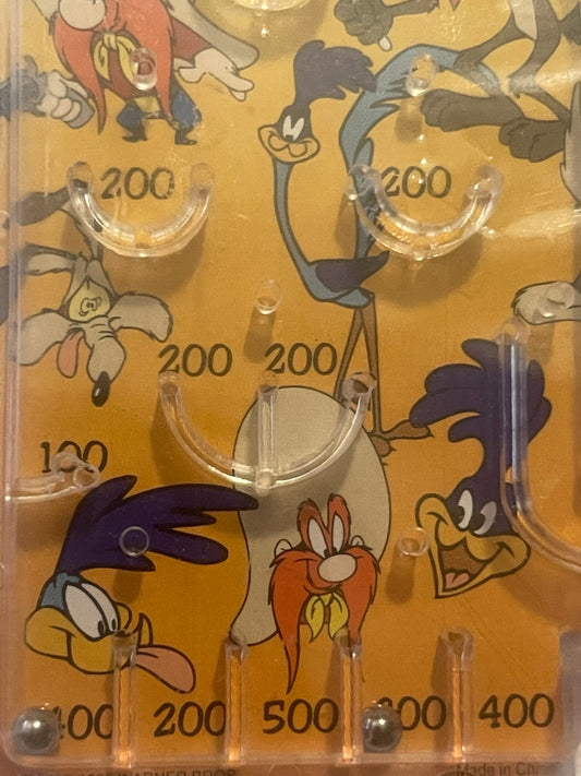 Amber pinball playfield with cartoon characters and scoring zones labeled 100-500, viewed from above