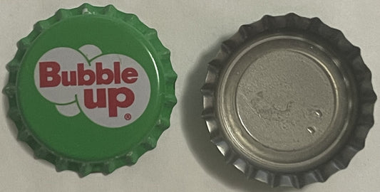 Two Bubble Up crown caps side by side: the green printed face, and the bare silver interior of a second cap.