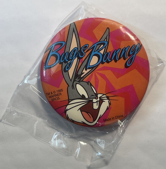 Sealed plastic bag containing a circular pin featuring Bugs Bunny's cartoon face with "Bugs Bunny" text on red and orange geo