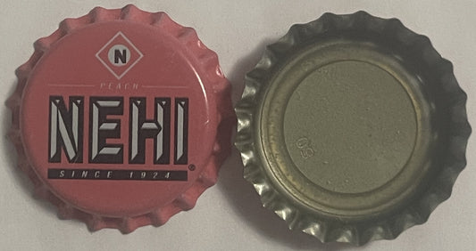 Front and back of a red Nehi Peach bottle cap with "N" logo and "Since 1924" text, alongside its metallic interior