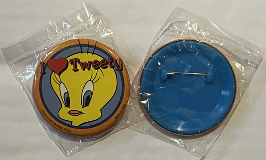 Two circular pins in clear plastic packaging showing Tweety Bird character with "I ❤ Tweety" text on front and blank blue bac