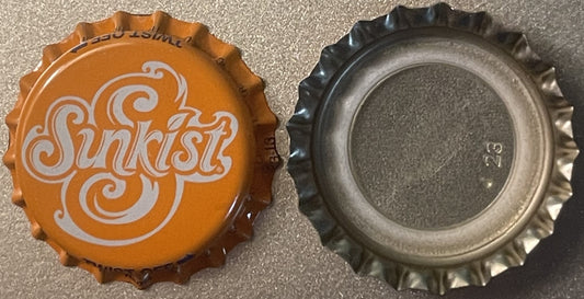 Vintage Sunkist orange soda bottle cap shown front and back, orange side displays white decorative swirl lettering, reverse s