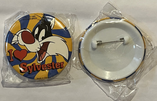 Two views of a sealed plastic package containing a round Sylvester pin with blue, yellow, and gold striped background, showin