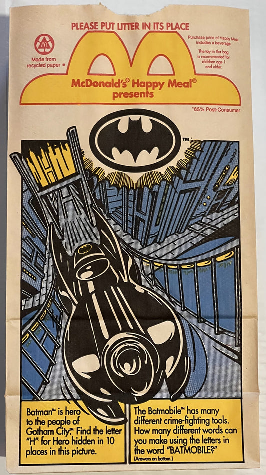 Vintage McDonald's Happy Meal paper bag featuring Batman logo, Batmobile illustration, and activity puzzles on tan recycled p