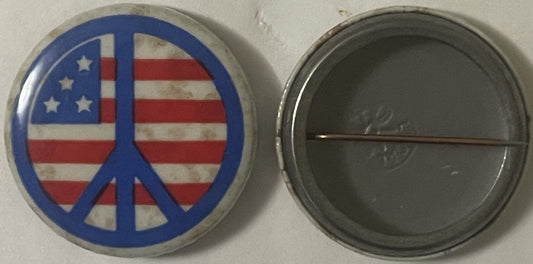 Front and back of a circular pinback button featuring a blue peace symbol overlaid on an American flag with red and white str