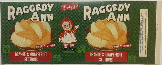 Vintage Raggedy Ann canned fruit label featuring whole orange and grapefruit sections in light syrup, with red-haired doll ch