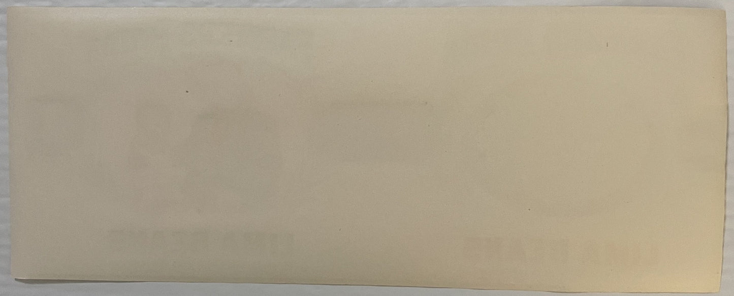 Blank cream-colored vintage label or packaging material photographed flat against neutral background