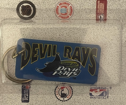 Vintage 1990s Tampa Bay Devil Rays blue keychain with manta ray logo, surrounded by MLB and team logos on textured background