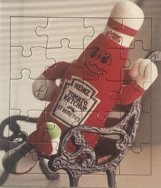 Vintage Heinz Ketchup mascot puzzle showing red anthropomorphic bottle with smiling face holding ketchup bottle, displayed as