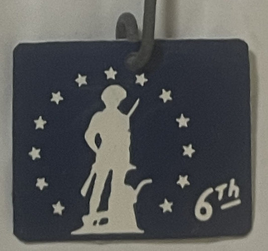 Blue side of the 6th War Loan tag: white Minute Man with musket and plow in a ring of 13 white stars, 6th in the lower corner